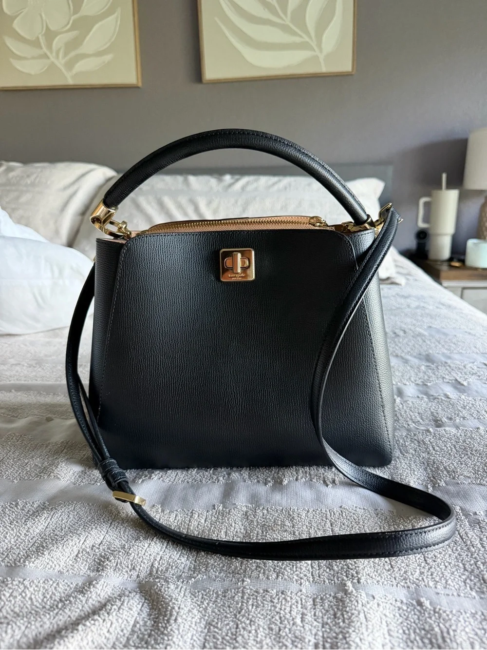 Kate Spade Phoebe black refined grain leather satchel with gold-tone hardware.